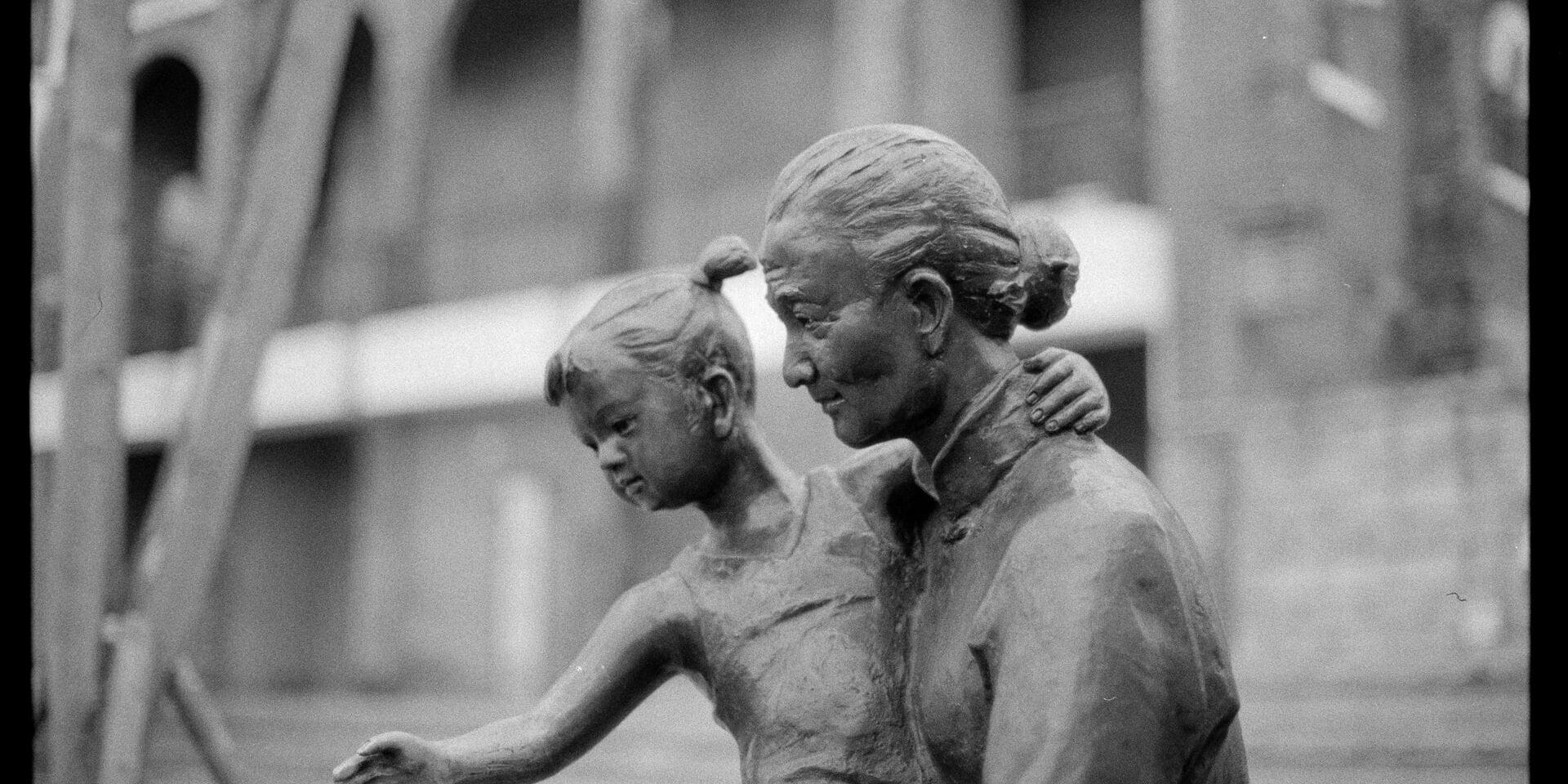 Escultura de una madre cargando a su hija